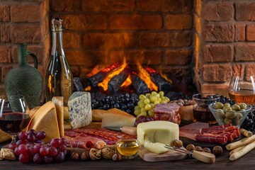 Charcuterie plate board, meat, boiled pork, smoked meats, prosciutto, and wine. Cheese pieces, nuts, grapes, honey on a wooden table. Refreshments and tasting alcoholic drinks in the wine cellar
