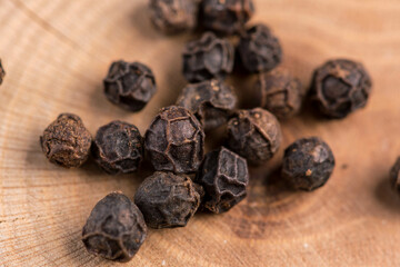 Peppercorns in warm light on wood close-up
