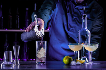 Bartender's hands serving cocktails on bar counter in a restaurant, pub. Mixed drinks. Alcoholic cooler beverage at nightclub on dark background