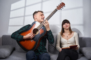 Couple playing guitar, reading a book