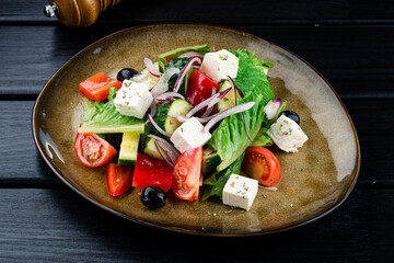 Greek salad with feta cheese, olives and vegetables on a plate