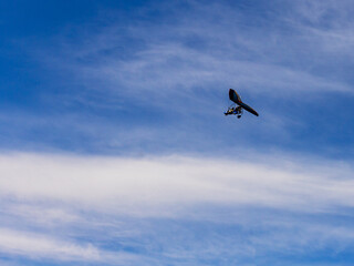 Flying a motorized hang glider on an autumn sunny day.