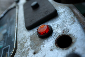 Rusty metal front panel in the old car with red button