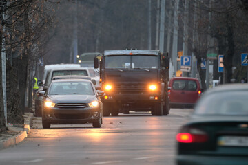 Traffic jam with many cars moving slowly on city street at night. Urban transportation concept