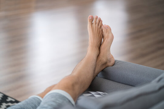 Tired man resting after work at home, male feet, body care concept
