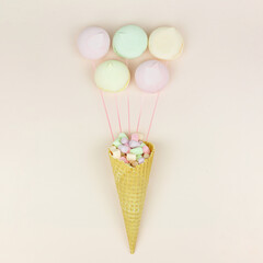 Wafer horn and marshmallow looks like macaroonson a pastel background, top view, flat lay, minimalist trend. Holiday and celebration concept