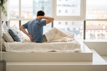 Back pain, man with backache at bedroom
