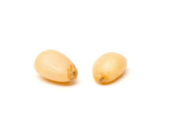 Siberian Peeled pine nuts isolated on white background. Healthy nuts snacks. Clipping path, full depth of field. Closeup view.