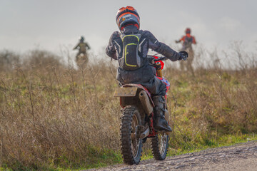 a motor cyclist (biker) riding their off-road motorbike along a stone track on Salisbury Plain, Wiltshire