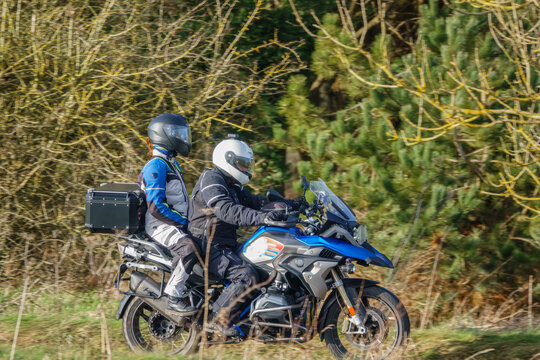 Motorbike Rider And Pillion Passenger On A BMW R1200 GS Motorcycle Travelling Through Winter Countryside