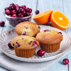 Cranberry orange muffins on wooden plate, square format