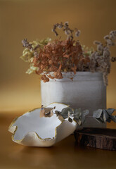 Dry flowers arrangement in stone vase with clay bowl with gold 