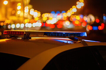 Emergency light of a traffic police car and night city street blurred (defocused) in the...
