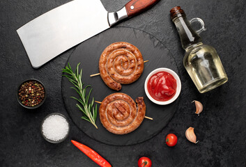 grilled sausages in the form of a spiral on skewers on a stone background