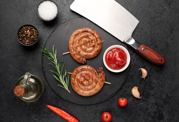 grilled sausages in the form of a spiral on skewers on a stone background