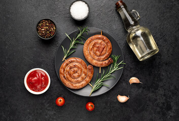 grilled sausages in the form of a spiral on skewers on a stone background