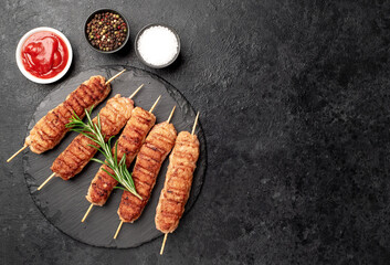 grilled lula kebab on skewers with spices on a stone background with copy space for your text