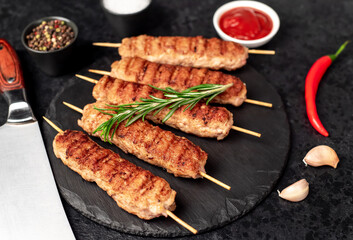 grilled lula kebab on skewers with spices on a stone background