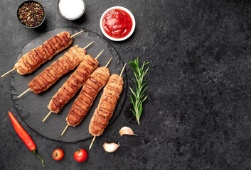 grilled lula kebab on skewers with spices on a stone background with copy space for your text © александр таланцев