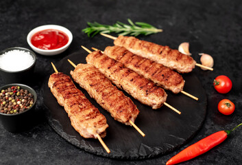grilled lula kebab on skewers with spices on a stone background