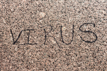 VIRUS inscription on the granite sidewalk. the name of the epidemic caused by the corona virus,