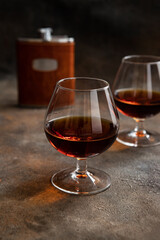 Two glasses of brandy or cognac on  dark table
