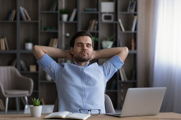 Calm businessman with closed eyes leaning back resting in office chair during break, satisfied man...