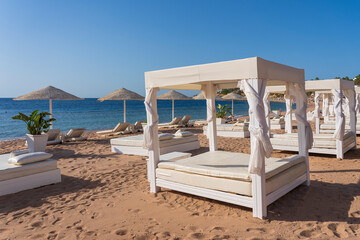 White sun canopy with mattress on luxury sand beach in tropical resort in Red Sea coast in Egypt, Africa