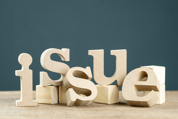 Issue word by wooden alphabets setup with wood cubes on the table