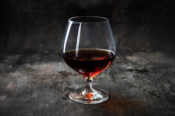 Armagnac,  brandy, cognac - strong alcoholic drink in glass  on dark background
