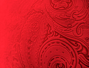 Bright red paisley pattern. Abstract blurred background made of textured fabric