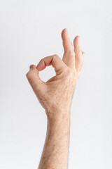 old man's hand making ok gesture white background