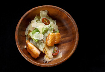 Caesar Salad with Grilled Salmon on wooden Plate Isolated. Salad with Red Fish Fillet, Mini Baguette Crackers.