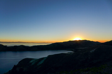 Fototapeta premium Beautiful sunset behind the silhouette of the mountains on the Isla del Sol with a clear, blue sky. Lake Titicaca - Bolivia