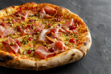 Ham pizza prepared in a wood-fired oven