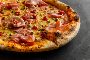 Ham pizza prepared in a wood-fired oven.