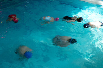 Children swimming training in a swimming pool. float exercise for buoyancy and proper breathing....