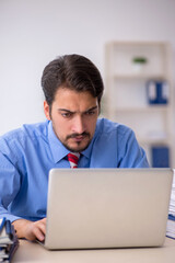 Young male employee unhappy with excessive work in the office