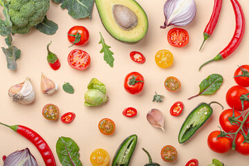 Creative cooking healthy organic food concept background made of colourful fruit and vegetables on beige background flat lay: tomatoes, broccoli, avocado, onion, garlic, herbs top view
