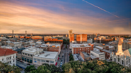 Aerial view of Savannah historic district in Georgia before sunset with a few high rise buildings, church of the ascension of wright square and bull street