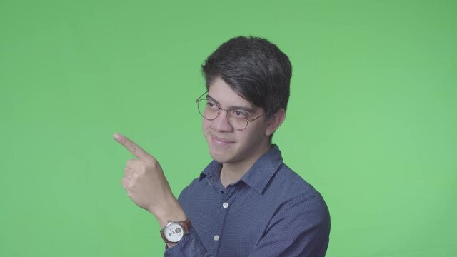 hombre latino diciendo si con la cabeza y Se&ntilde;alando a un lado con fondo verde