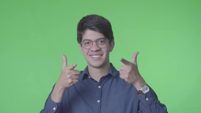 hombre latino diciendo si con la cabeza y Se&ntilde;alando al frente picando el ojo con fondo verde