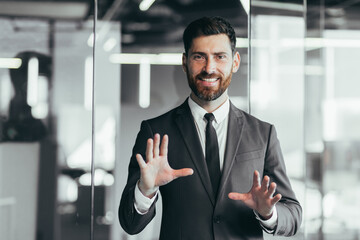 Fototapeta premium Businessman looking at camera and talking on video call, having fun gesturing with hands, webcam view