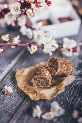 Spring collection of handmade chocolate bonbons candies and cherry flowers decoration on rustic wooden background