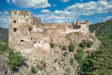 Fototapeta na wymiar Aerial summer view of Sasov castle in Slovakia above the Hron river with circular donjon tower and partially restored walls on a hilltop
