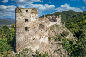 Fototapeta na wymiar Aerial summer view of Sasov castle in Slovakia above the Hron river with circular donjon tower and partially restored walls on a hilltop