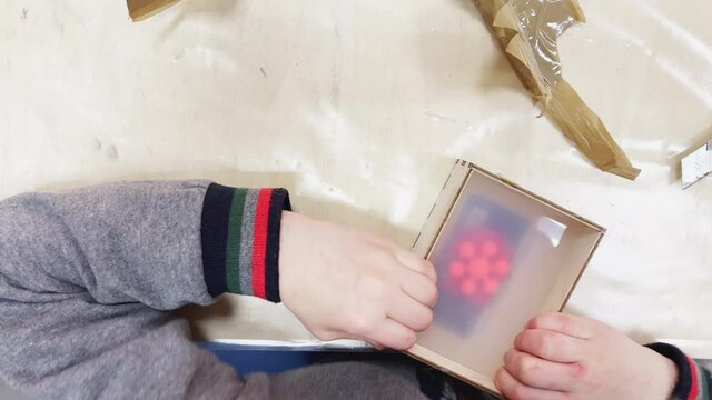 Children's hands disassemble the mold of rubber, the matrix for making plastic products, construction tools are on the table