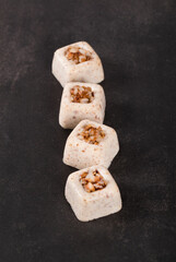 Buckwheat cream jelly in the form of small portions of a square shape on a dark gray background