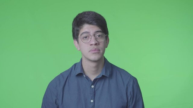 Hombre triste y decepcionado suspirando con fondo verde