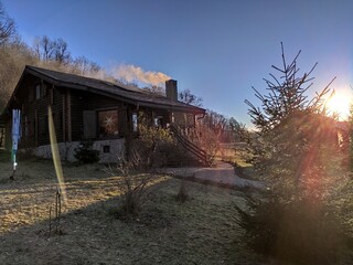 Fototapeta premium Romania,wooden cottage ,chalet near the forest in Bistrita eastern Transylvania, january 2020, the smoke coming out of the chimney 